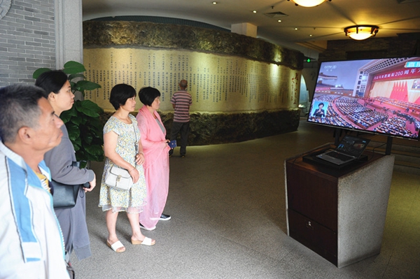 游客通过本馆电子显示屏观看大会直播