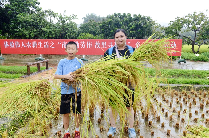 以坚强意志冒雨割完稻谷后的少年与母亲合影留念