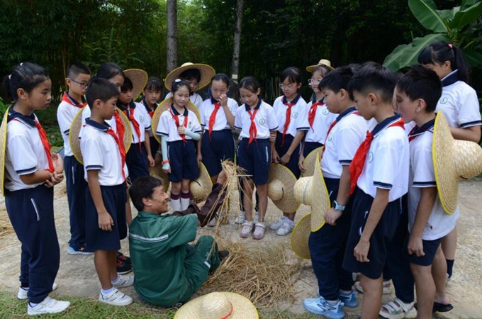 翠亨小学学生向工作人员学习制作草绳